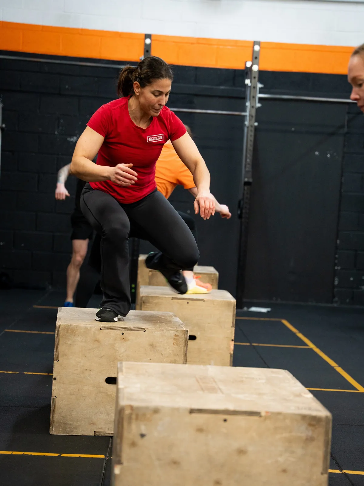 A coach mid box jump during a class at CrossFit Bletchley