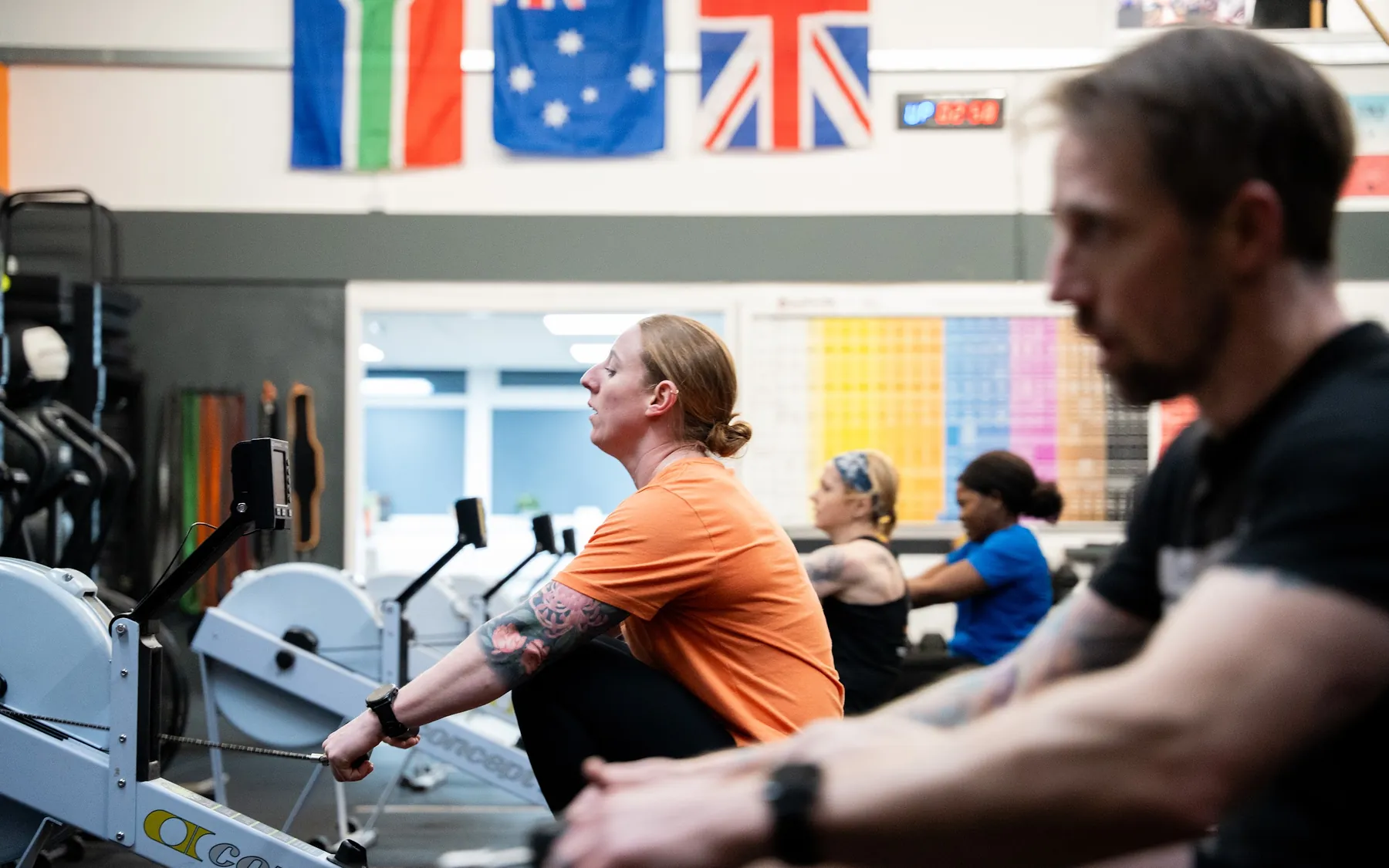 A row of members working on the Concept2 rowers